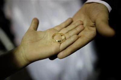 A couple shows a wedding ring as they celebrate in Brasil, Aug. 13, 2011.