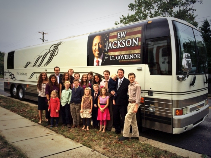 Jim Bob Duggar, former Arkansas state senator and television personality, stands with his wife and 19 children in front of a bus promoting E.W. Jackson, Republican candidate for attorney general.