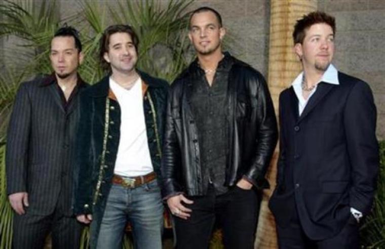 Members of the rock band Creed, from left: bassist Brett Hestia, Singer Scott Stapp, guitarist Mark Tremonti, and drummer Scott Phillips arrive at the 2002 Billboard Music Awards show at the MGM Grand Garden Arena in Las Vegas, Nev., Dec. 9, 2002. Creed won four awards, including group/duo of the year.