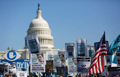Demonstrators hold up their signs during the 'Stop Watching Us: A Rally Against Mass Surveillance' march near the U.S. Capitol in Washington, October 26, 2013.