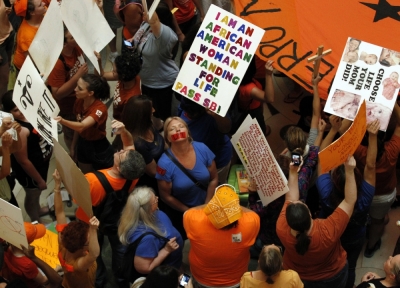 Abortion activists (in orange) and pro-life advocates (in blue) rally in the rotunda of the State Capitol in Austin, Texas in this July 12, 2013 file photo.
