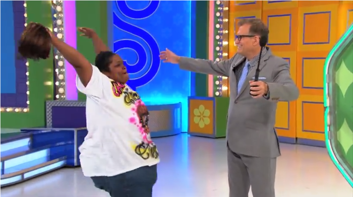 The Price Is Right contestant, Aliayah (l), wigs out after winning the One Bid section of the show. Show host, Drew Carey, looks on.