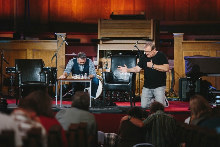 Pastor Rick Warren (R) prays with Resurgence movement founder Mark Driscoll during conference at Mars Hill Downtown Church in Seattle, Nov. 6, 2013.