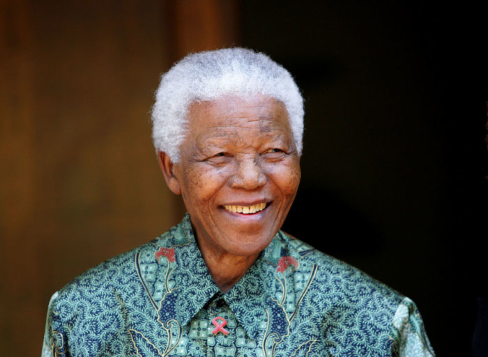 Former South African President Nelson Mandela smiles for photographers after a meeting with actor Tim Robbins at Mandela's home in Johannesburg September 22, 2005. Robbins is currently in South Africa filming.