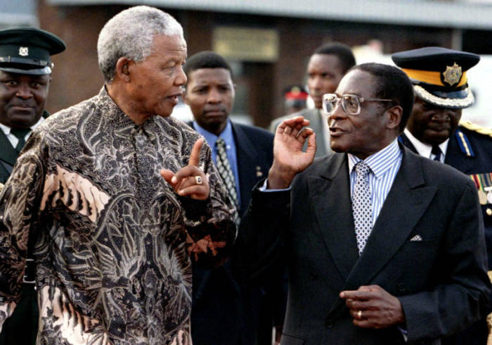 President's Nelson Mandela of South Africa (L) and Robert Mugabe of Zimbabwe talk together May 21, 1997, as he was leaving the country after a three day state visit. Mandela opened a World Economic Forum on the southern African region to improve investment and trade within the region.