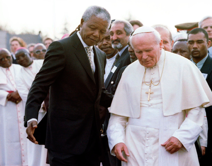 South African President Nelson Mandela (L) guides Pope John Paul II after they met at Johannesburg International Airport, at the start of the pope's first official visit to the country, in this file picture taken September 16, 1995.