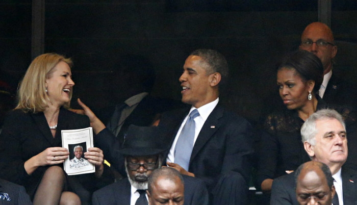 U.S. President Barack Obama (C) shares a moment with Denmark's Prime Minister Helle Thorning-Schmidt (L) as his wife, first lady Michelle Obama looks on during the memorial service for late South African President Nelson Mandela at the First National Bank stadium, also known as Soccer City, in Johannesburg on Dec. 10, 2013.