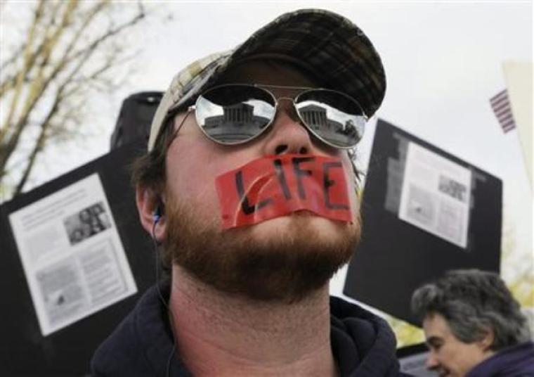 The Supreme Court building is reflected in an anti-abortion protester's sunglasses as he prays during the third and final day of legal arguments over the Patient Protection and Affordable Care Act at the Supreme Court in Washington, D.C., in this March 28, 2012, file photo.