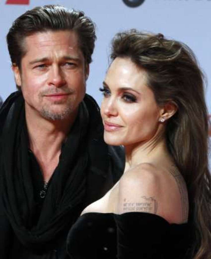 U.S. actors Angelina Jolie (R) and Brad Pitt pose for pictures as they arrive for the European premiere of the movie "The Tourist" in Berlin, December 14, 2010.
