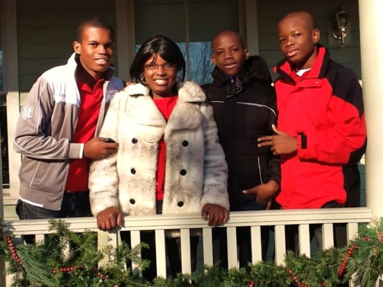 Raymonde Exantus and her sons Ralph, Junior and Marc, stand on the porch of their Habitat home, which was constructed partly from the 2010 Rockefeller Center Christmas tree.