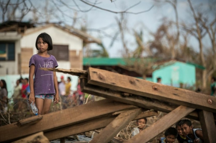 A child surveys the destruction following Typhoon Haiyan.