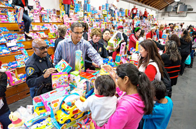 Miles McPherson, Rock Church senior pastor, and Shelley Zimmerman, the Assistant Police Chief for San Diego, hand out toys in the toy room at Toys for Joy.