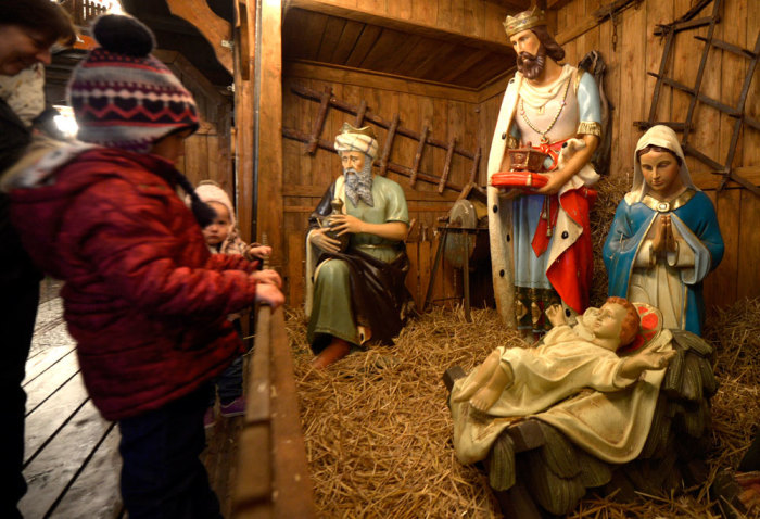 Children look at a Nativity scene at the Christmas market in the harbour of Emden, Germany, November 27, 2013.