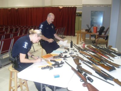 Police handle weapons turned in as part of New Life Fellowship Center's gun buy back program in 2010. The North Carolina has run the initiative for the past seven years.