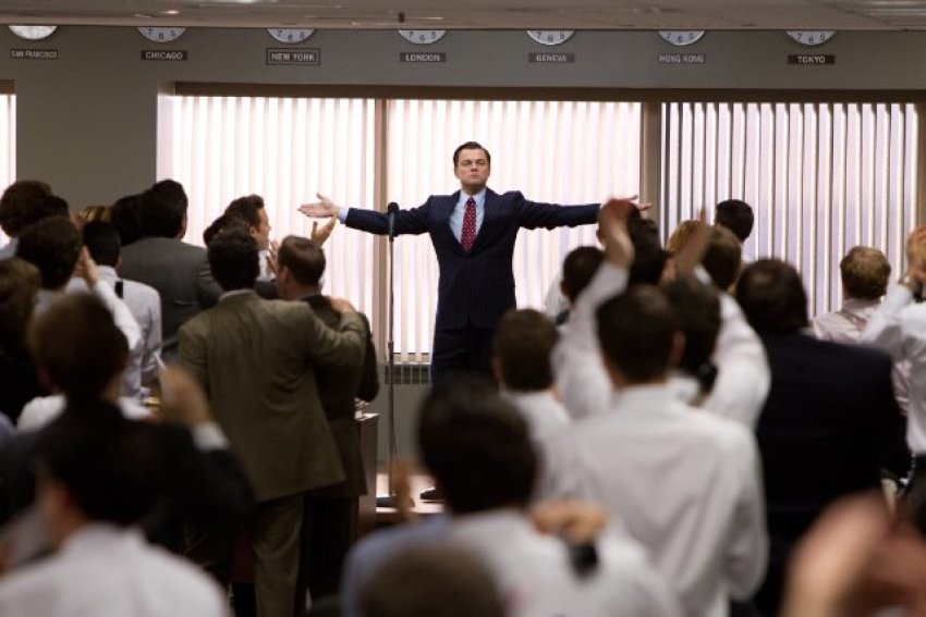 Jordan Belfort (Leonardo DiCaprio), "The Wolf of Wall Street," stands with his hands outstretched, declaring riches for his company through stock fraud.