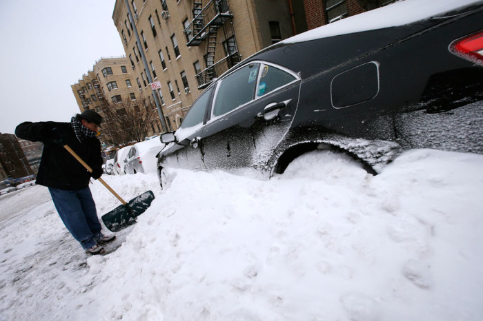 Carlos Mendez clears snow away from his car in the South Bronx section of New York City, January 3, 2014. A heavy snowstorm and dangerously cold conditions gripped the northeastern United States on Friday, delaying flights, paralyzing road travel and closing schools and government offices across the region.