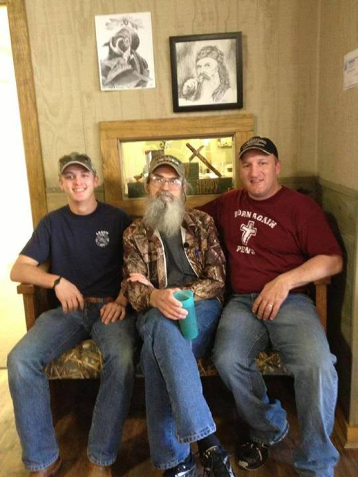 Uncle Si (center) of 'Duck Dynasty' sits on a pew designed specifically in honor of the television show, with the founder of Born Again Pews, Rex Blisard (right) and Blisard's son-in-law Nick Howard (left).