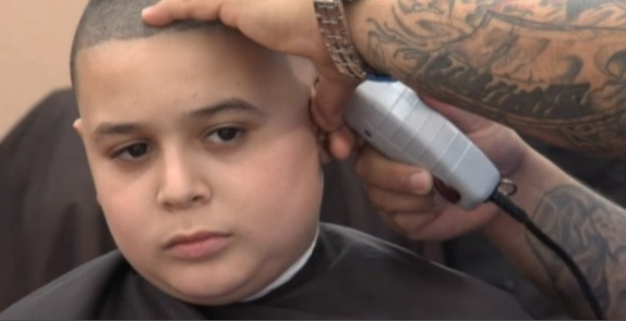 Danny Valdes, 11-years-old, gets a haircut from his stepfather Arnaldo Fernandez.