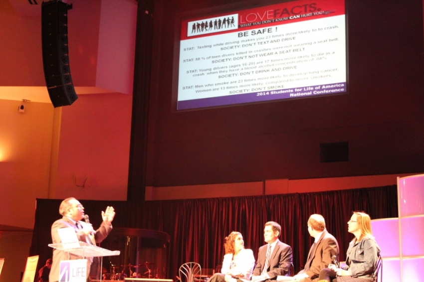 Kevin Bagetta, founder of LoveFacts.org, turns to present facts about "safe sex," while Russell Moore, Marguerite Duane, and Steve Aden look on, at the 2014 National Students for Life Conference in Upper Marlborough, Maryland.