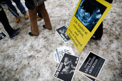 Signs are seen in the snow at the start of the annual March for Life rally in Washington, January 25, 2013.