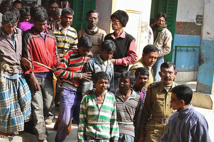 Indian police escort men (tied with rope), who are accused of gang-rape, from a court in West Bengal January 23, 2014. A 20-year-old woman in eastern India was allegedly gang-raped by 13 men on the orders of a village court as punishment for having a relationship with a man from a different community.