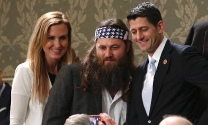 Duck Dynasty star Willie Robertson and his wife Korie pose for a picture with congressman Paul Ryan.