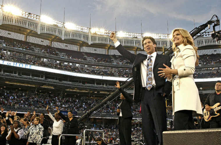 Lakewood Church pastors Joel and Victoria Osteen appear on stage at Yankee Stadium on April 25, 2009, in the Bronx borough of New York City for their 'Historic Night of Hope' worship gathering.