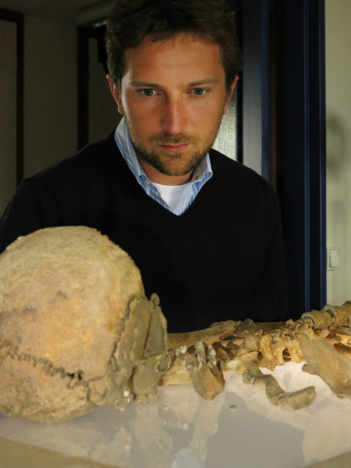 Michael Scott, presenter of NOVA's 'Roman Catacomb Mystery' airing Wednesday, Feb. 5, 2014, examines a human skeleton on display at Bordeaux University, and found in the X tombs of the Catacomb of Saints Peter and Marcellinus in Rome.