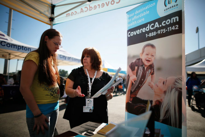 Maria Franco (R) explains health insurance to Violet Lucas-Barajas, 28, at an event to inform people about the Affordable Care Act in Los Angeles, California, November 25, 2013.