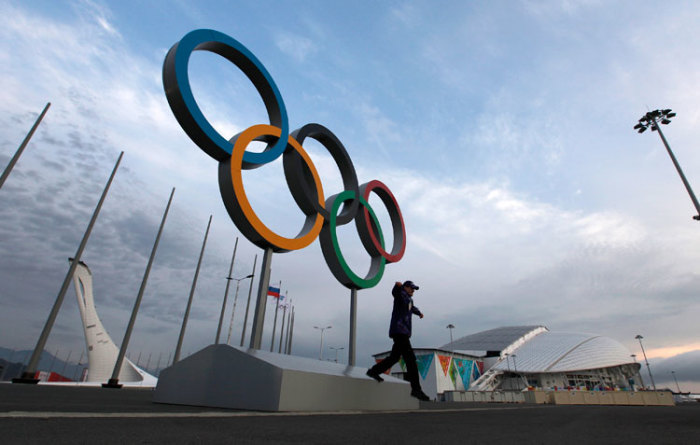 A man steps down from a platform displaying the Olympic rings on the Olympic Park outside the Fisht Stadium, January 28, 2014.