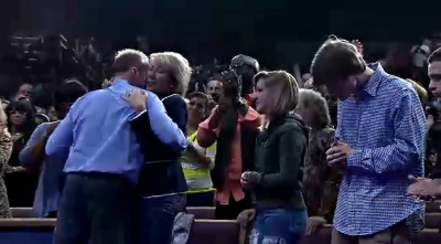 Ron and Hope Carpenter, founders of Redemption World Outreach Center in Greenville, S.C., embrace as congregants look on.