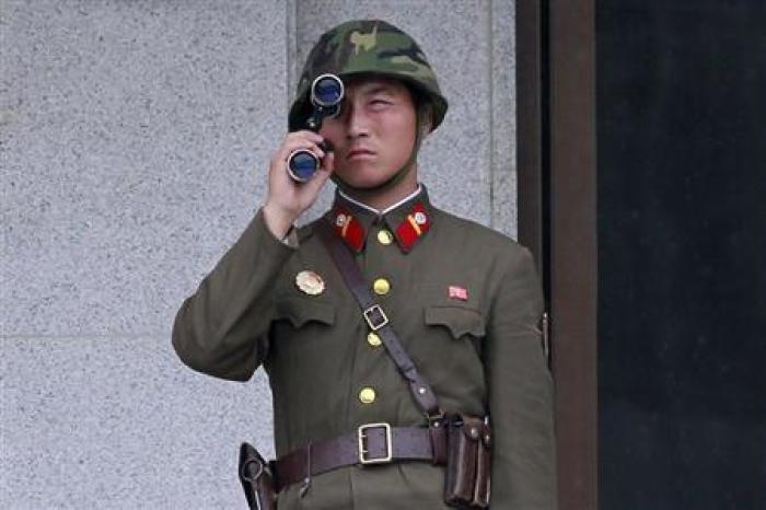 A North Korean soldier looks south through a pair of binoculars on the north side of the truce village of Panmunjom in the demilitarised zone separating the two Koreas in Paju, about 55 km (34 miles) north of Seoul, August 25, 2010.