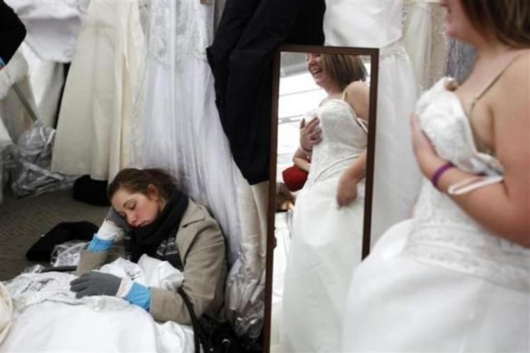 Dawn Schreiber falls asleep as the bride she is helping to look for dresses looks in a mirror inside Filene's Basement during a 'Running of the Brides' bridal dress sale in New York, Feb. 5, 2010.