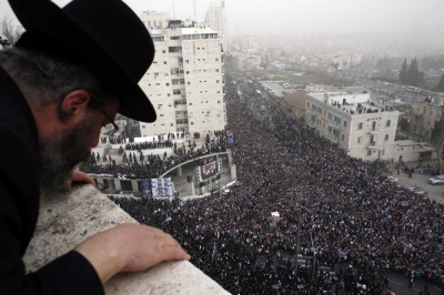 An ultra-Orthodox Jewish man looks down from a rooftop at a mass prayer in Jerusalem March 2, 2014.