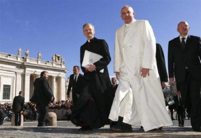 Pope Francis walks as he arrives to lead the general audience in Saint Peter's Square at the Vatican March 5, 2014.