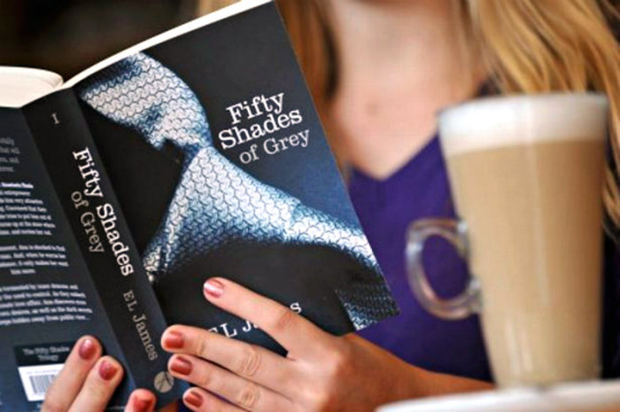 A woman reads E.L. James' 'Fifty Shades of Grey' erotica book.