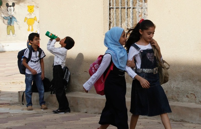 Iraqi children walk to their class in a school.