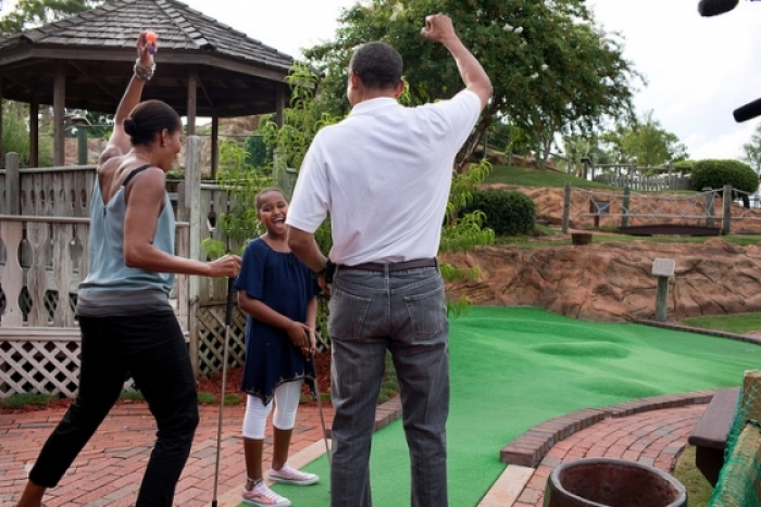 President Barack Obama and First Lady Michelle Obama react to daughter Sasha's hole in one while playing miniature golf at Pirate's Island Golf in Panama City Beach, Fla., Saturday, Aug. 14, 2010.
