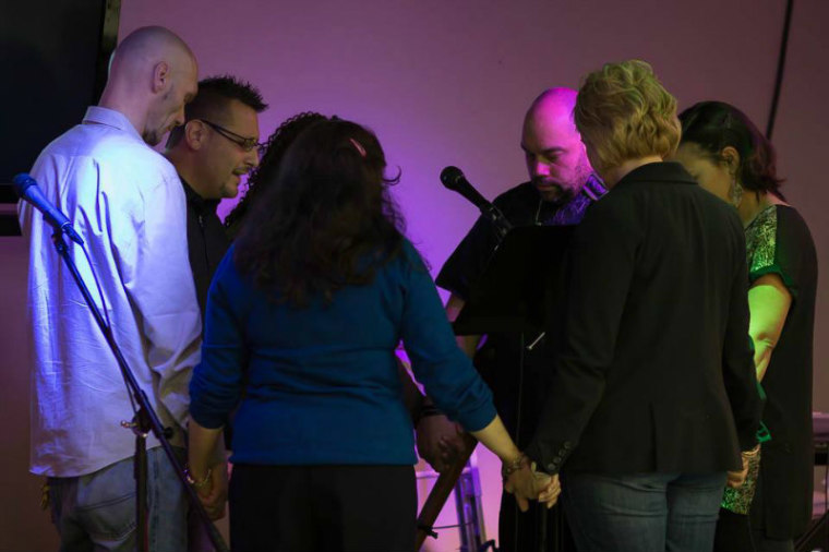 Members of New Song Church in the Bronx join hands in prayer.