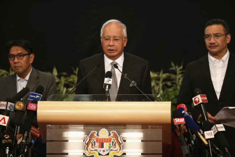 Malaysia's Prime Minister Najib Razak (C) makes an announcement on the latest development on the missing Malaysia Airlines MH370 plane at Putra World Trade Center in Kuala Lumpur March 24, 2014. Prime Minister Najib has told families of passengers of a missing Malaysian airliner that the plane ended its journey in the southern Indian Ocean, he said on Monday. Seen on right is Malaysia's acting Transport Minister Hishammuddin Hussein and on left is Department of Civil Aviation's Director General Azharuddin Abdul Rahman.