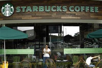 A customer with a cup of coffee leaves the new Starbucks store in San Jose, Calif., June 20, 2012.