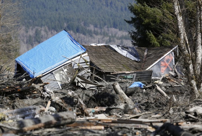 A landslide and structural debris blocks Highway 530 near Oso, Washington March 23, 2014. Eighteen people remain unaccounted for in a landslide that killed three and injured at least eight more in northwestern Washington state, officials said Sunday.