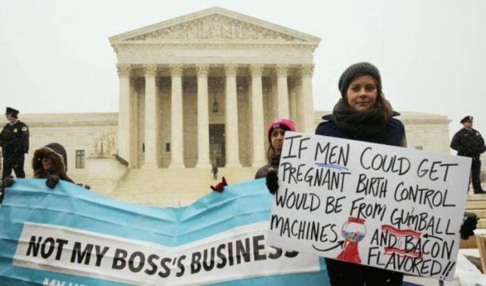 Protester Julia Mitchell holds a sign at the steps of the U.S. Supreme Court as arguments began to challenge the Affordable Care Act's requirement that employers pay for contraception and abortion-inducing drugs as part of an employee's healthcare, in Washington, March 25, 2014.