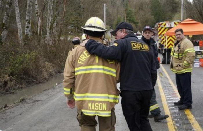 Snohomish County Fire Chief Steve Mason (L) talks with a chaplain near the mudslide near Oso, Washington as efforts continued to find victims March 26, 2014.