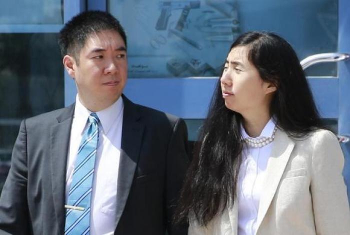 Matthew (L) and Grace Huang, a U.S. couple who were accused of murdering their adopted daughter Gloria, stand outside the entrance of the Court of First Instance after their trial in Doha, March 27, 2014.