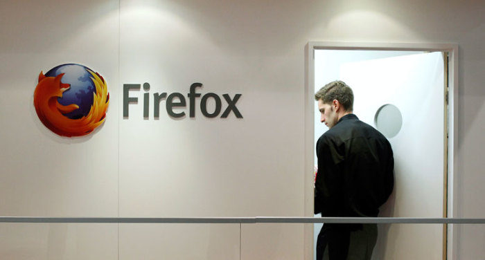 A man is seen next to a Firefox logo at a Mozilla stand during the Mobile World Congress in Barcelona, February 28, 2013.