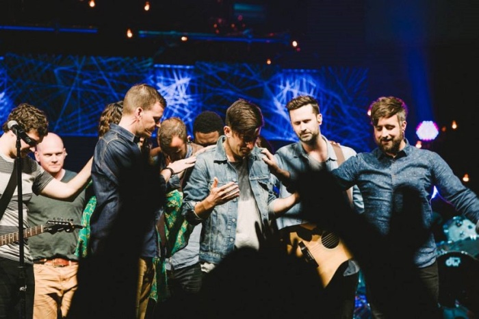 Recording artist and worship leader Phil Wickham (center) had to cancel his performance at Catalyst West as the result of an irregularity on his left vocal cord. Wickham appeared on stage while Catalyst leaders and those in attendance prayed for him, April 3, 2014.