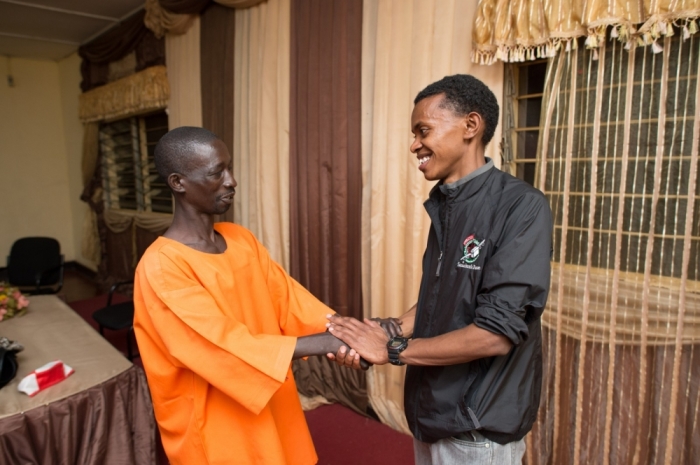 Alex Nsengimana (R) visiting the man who killed his uncle at a prison in Rwanda in March 2013.