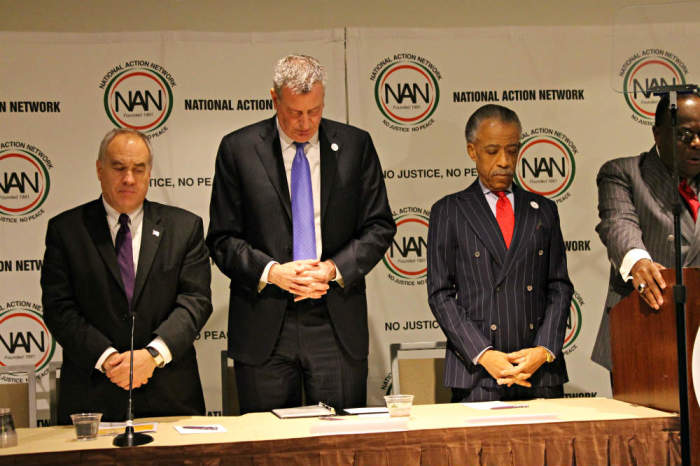 (L-R) New York State Comptroller Thomas P. DiNapoli, New York City Mayor Bill De Blasio and the Rev. Al Sharpton, founder and president of the National Action Network, bow their heads in prayer on Wednesday, April 9, 2014, during the NAN 2014 Convention at the Sheraton Hotel in New York City.