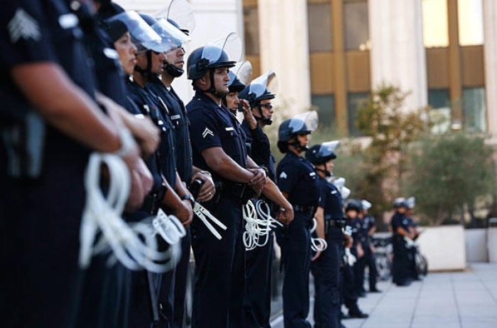 Los Angeles Police Department officers stand outside police headquarters during a rally organized by the Act Now to Stop War and End Racism (ANSWER) coalition in Los Angeles Tuesday to protest the acquittal of George Zimmerman for the shooting death of Florida teenager Trayvon Martin.